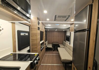 Interior view of CORE RV toy hauler showing the living space, kitchen and entertainment cabinet.